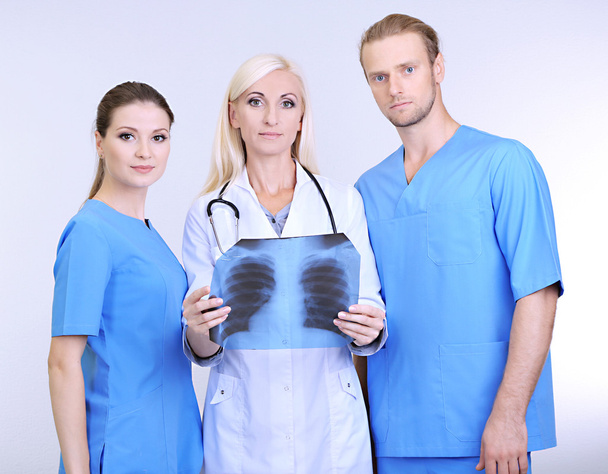 Medical workers on grey background - Valokuva, kuva