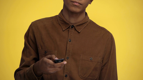 recortado vista de afroamericano adolescente viendo tv aislado en amarillo
 - Imágenes, Vídeo