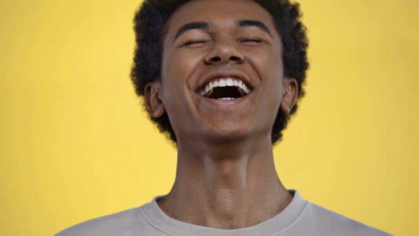 Африканський підліток, який посміхається перед камерою, ізольований жовтим. - Кадри, відео