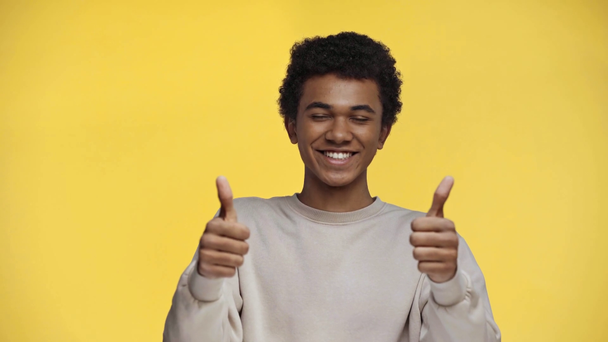 adolescente afroamericano señalando con el dedo aislado en amarillo
 - Imágenes, Vídeo