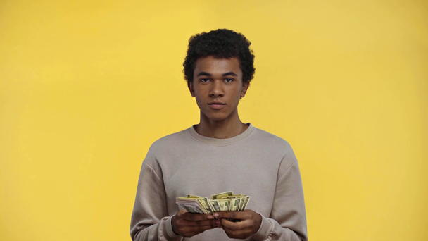 Afrikaans amerikaanse tiener tellen geld geïsoleerd op geel - Video