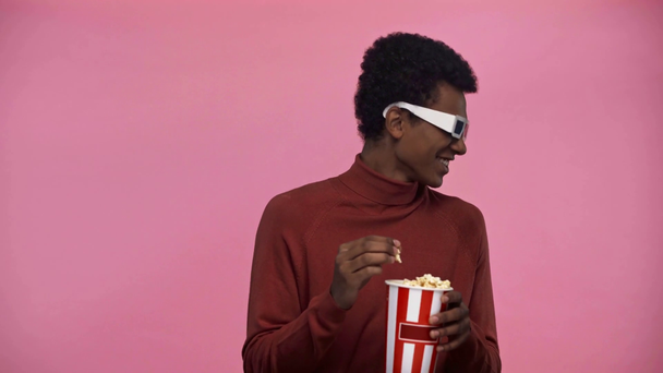 Afrikanischer amerikanischer Teenager schaut Film isoliert auf rosa - Filmmaterial, Video