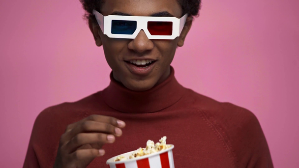 african american teenager watching movie isolated on pink - Footage, Video