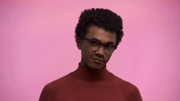 afro-amerikai tinédzser mosolyog a kamera elszigetelt rózsaszín - Felvétel, videó