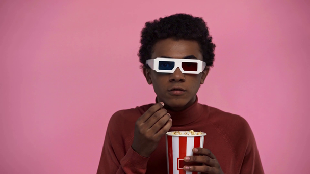 africký americký teenager sledování film izolovaný na růžové - Záběry, video