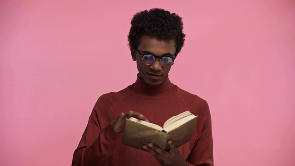 afroamericano adolescente lectura libro aislado en rosa
 - Metraje, vídeo