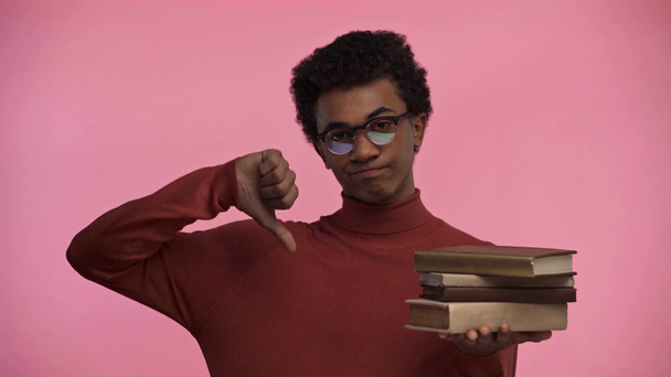 africano americano adolescente segurando livros isolados em rosa
 - Filmagem, Vídeo