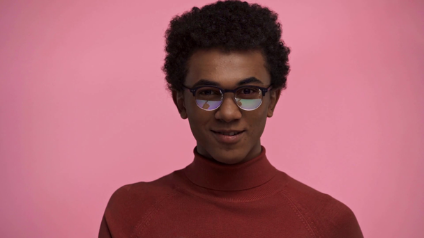 africký americký teenager ukazuje prstem izolovaným na růžové - Záběry, video