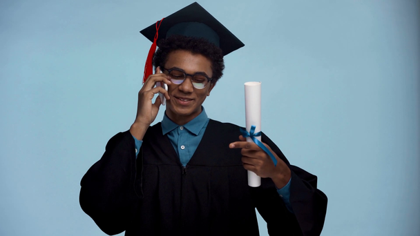 africano americano adolescente falando no smartphone isolado no azul
 - Filmagem, Vídeo