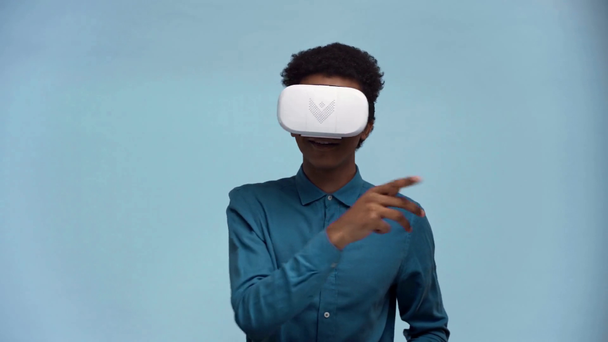 african american teenager with virtual reality headset isolated on blue - Footage, Video