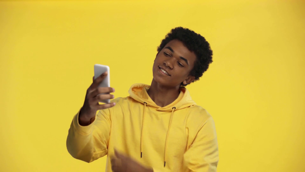 Afrikanischer Teenager macht Selfie isoliert auf gelb - Filmmaterial, Video