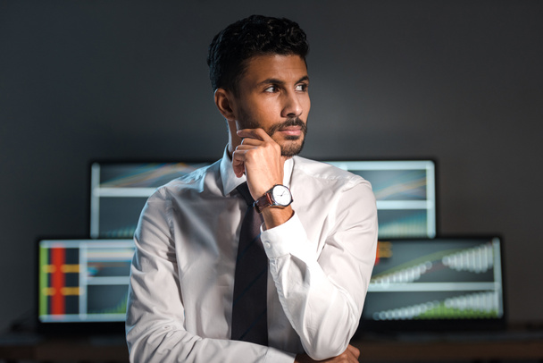 pensive and handsome bi-racial trader looking away in office  - Photo, Image