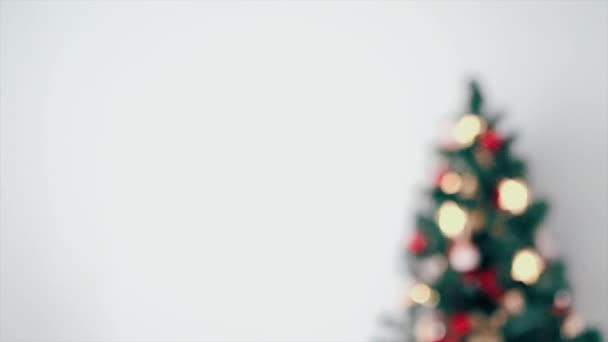 Gedecoreerde kerstboom aan de rechterkant van het frame met slinger op witte achtergrond - Video