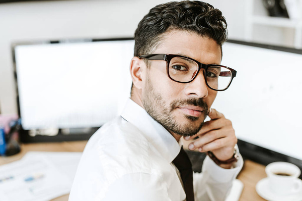 bi-racial trader in glasses looking at camera in office  - Photo, Image
