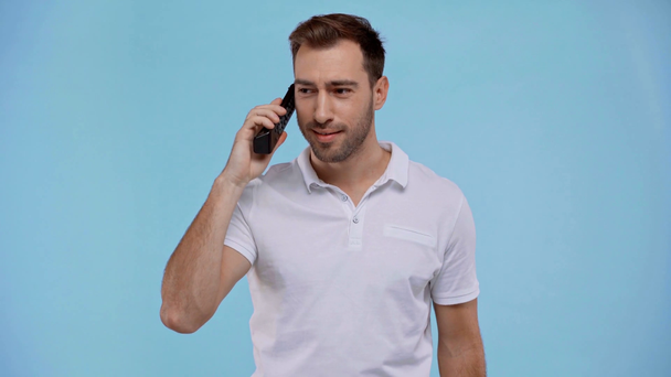 άνθρωπος κρατώντας τηλεχειριστήριο και μιλώντας απομονωμένο σε μπλε - Πλάνα, βίντεο