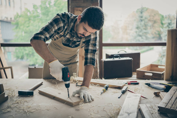 Portrait of his he nice attractive serious focused hardworking experienced guy repairman drilling creating new house building project order gift shop at modern industrial loft style interior - 写真・画像