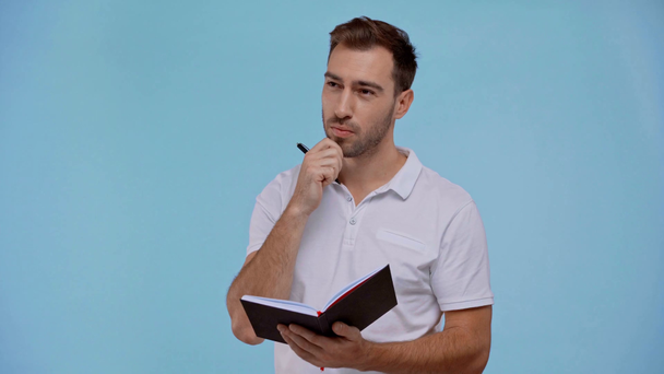 přemýšlivý muž psaní v notebooku izolované na modré - Záběry, video