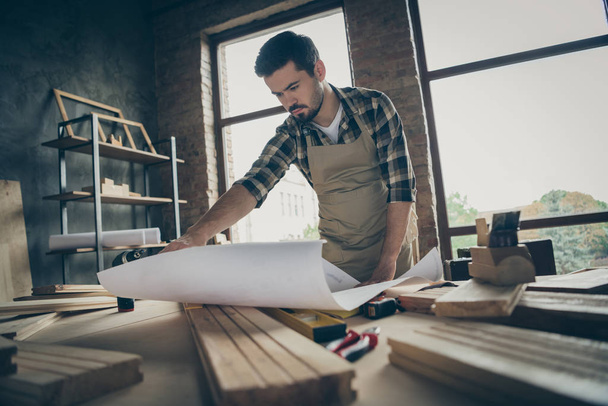 Portrait of his he nice attractive serious focused hardworking skilled experienced guy repairman reading plan new house building project at modern industrial loft style interior indoors - Photo, Image