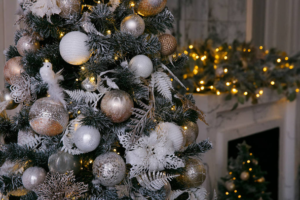 Golden and white Christmas decorations on the New Year tree in the home interior - Valokuva, kuva