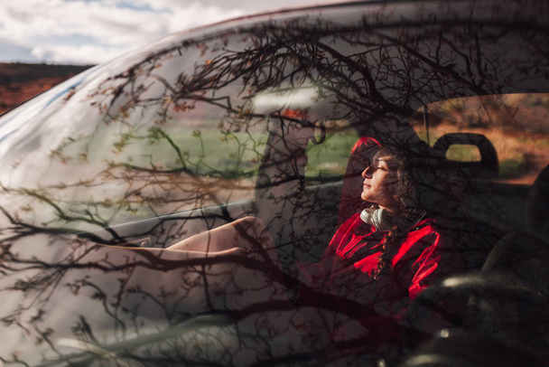 Молода жінка бере притулок всередині машини під час дощу
 - Фото, зображення