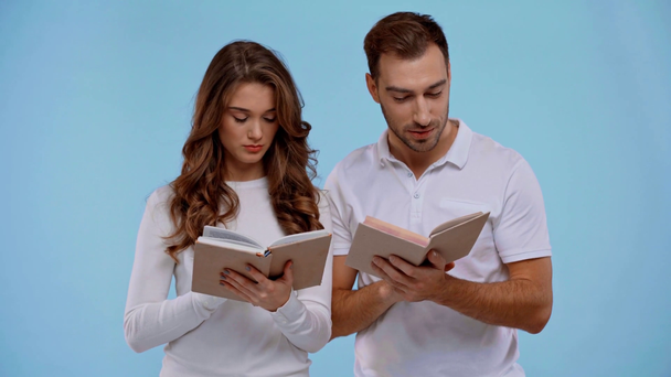 Kız arkadaş ve erkek arkadaş mavi üzerine kitap okuyorlar. - Video, Çekim