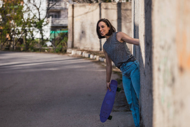 Mladá žena s modrým penny skateboard v ležérní nošení - Fotografie, Obrázek