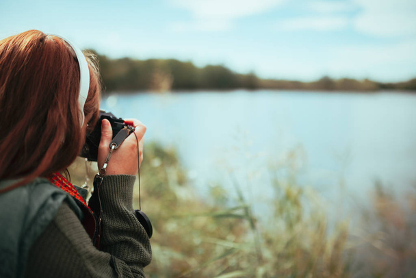 Νεαρή γυναίκα τραβάει φωτογραφίες στο δάσος με μια παλιά κάμερα - Φωτογραφία, εικόνα