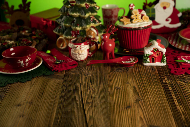 Weihnachtszeit. weihnachtliches Geschirr und Dekorationen. rote und braune Farben. rustikaler Holzhintergrund. - Foto, Bild
