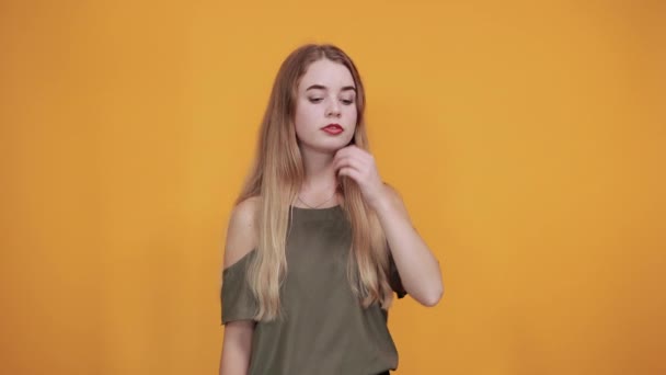 Cute woman putting hand prop up on ear, keeping finger on mouth, shh gesture - Felvétel, videó