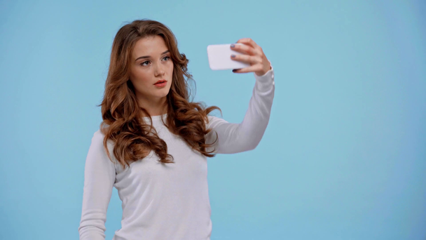 Frau macht Selfie isoliert auf blauem Grund - Filmmaterial, Video