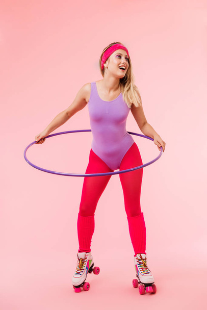 Image of pleased beautiful woman doing exercise with hula hoop - Фото, зображення
