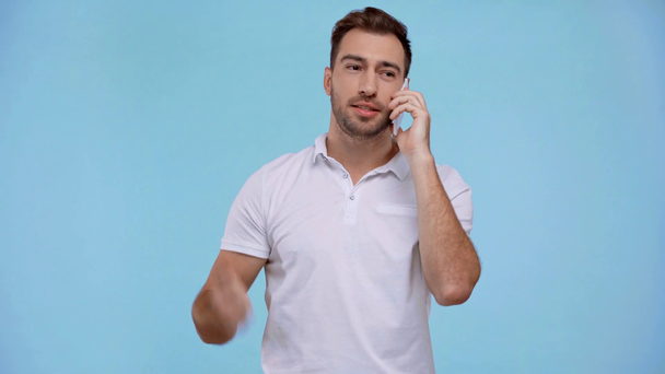 smiling man talking on smartphone isolated on blue - Filmmaterial, Video