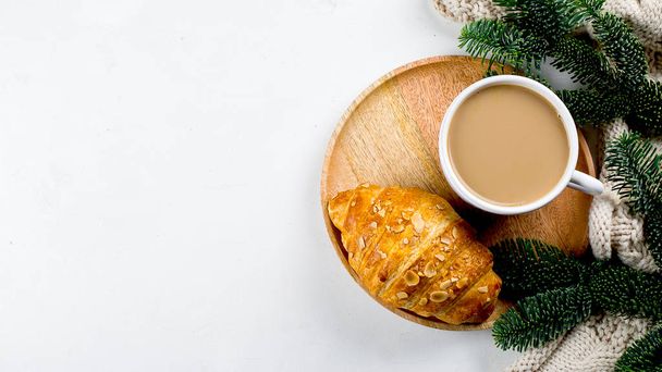Christmas breakfast. Cup of coffee, croissant and holiday decoration toys, tree fir branches on white table. background. Top view, flat lay. Banner image - Photo, Image