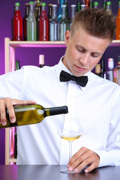 Bartender is pouring white wine into glass - Φωτογραφία, εικόνα