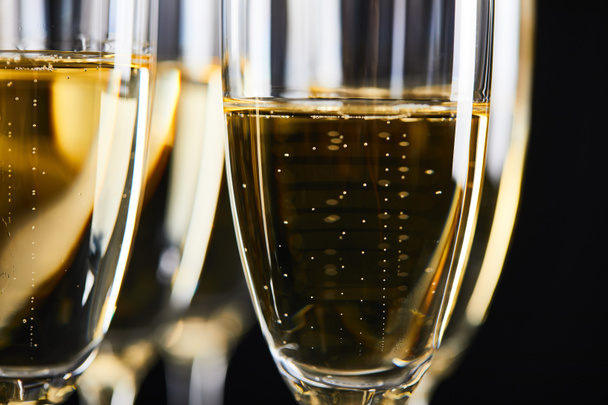 close up of sparkling wine in glasses for celebrating christmas, isolated on black  - Fotografie, Obrázek