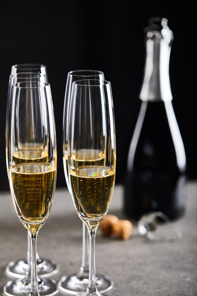 glasses and bottle of sparkling wine for celebrating christmas on black - Foto, imagen