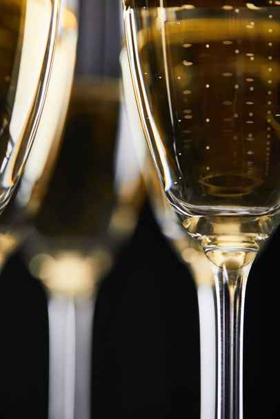 close up of glasses with champagne for celebrating christmas, isolated on black  - Zdjęcie, obraz