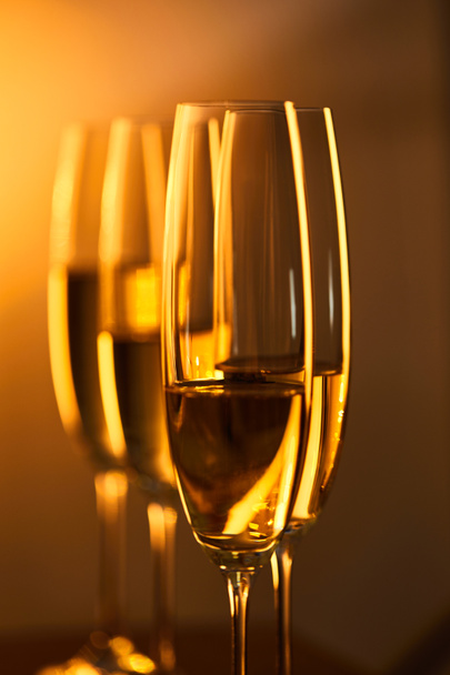 close up of glasses of champagne with blurred yellow christmas lights - Valokuva, kuva