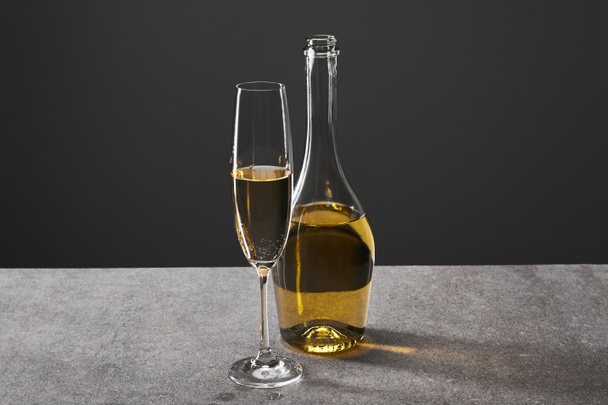 glass and bottle of champagne for celebrating christmas on grey - Φωτογραφία, εικόνα