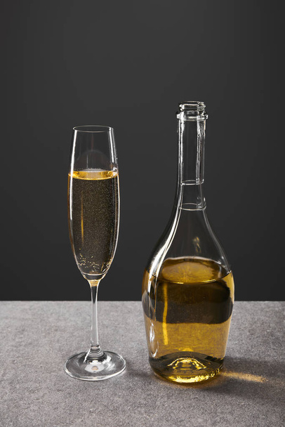 verre et bouteille de vin mousseux pour célébrer la veille de Noël sur gris
 - Photo, image