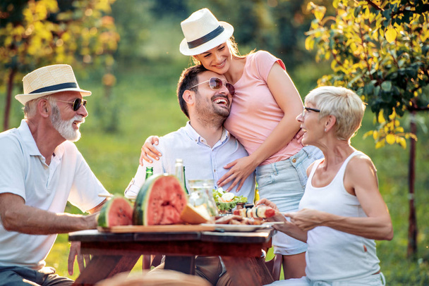 Šťastná velká rodina obědvá na letní zahradní párty. Lidé, jídlo, láska a štěstí koncept. - Fotografie, Obrázek