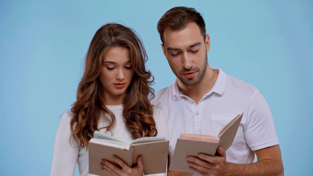 boyfriend and girlfriend talking and reading books isolated on blue - Footage, Video