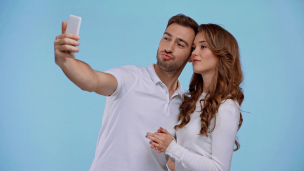 boyfriend and girlfriend taking selfie isolated on blue - Záběry, video