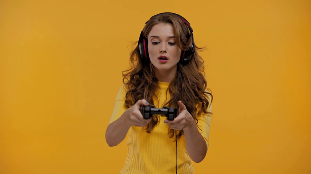 QUIIV, UCRÂNIA - SETEMBRO 13, 2019: Mulher jogando videogame isolada em amarelo
 - Filmagem, Vídeo