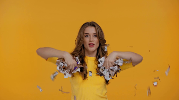 woman dancing with confetti isolated on yellow - Metraje, vídeo