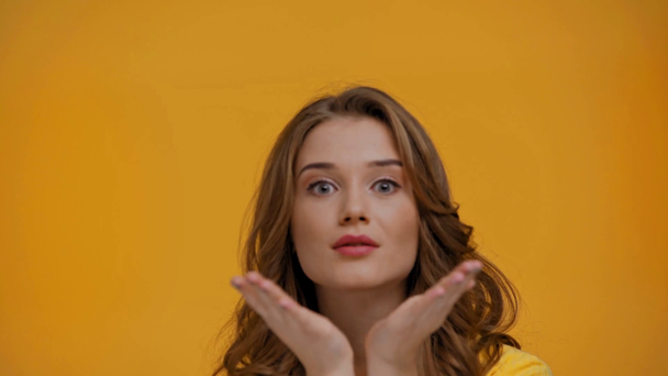 woman blowing kiss isolated on yellow - Séquence, vidéo
