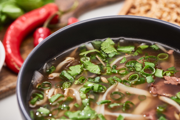 close up view of pho with noodles, meat, cilantro and green onion in bowl - Foto, immagini