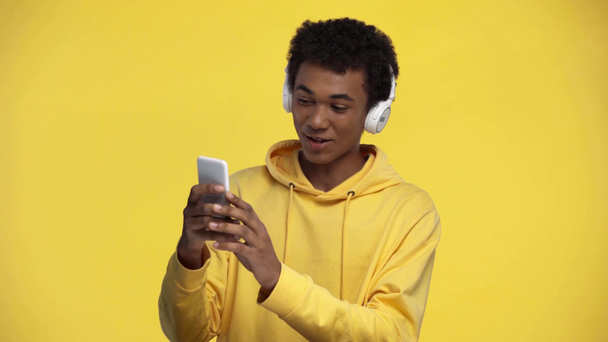 africano americano adolescente tener vídeo chat aislado en amarillo
 - Imágenes, Vídeo