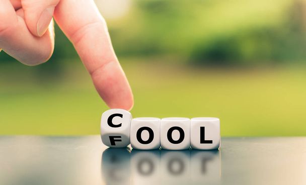 Be cool or a fool? Hand turns a dice and changes the word "fool" - Photo, Image