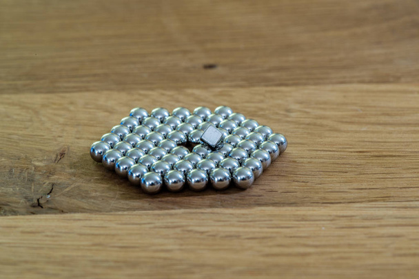bola de metal em um cubo de ímãs quadrados
 - Foto, Imagem
